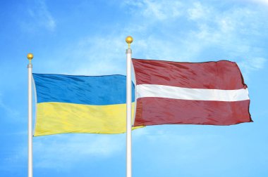 Ukrayna ve Letonya bayrak direkleri ve mavi bulutlu arka planda iki bayrak