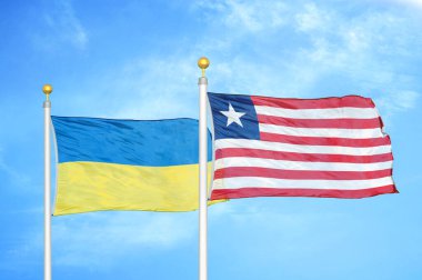 Ukrayna ve Liberya bayrak direkleri ve mavi bulutlu arka planda iki bayrak