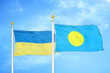 Ukrayna ve Palau bayrak direkleri ve mavi bulutlu arka planda iki bayrak