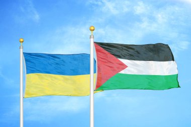Ukrayna ve Filistin bayrak direkleri ve mavi bulutlu arka planda iki bayrak