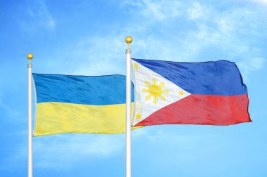 Ukrayna ve Filipinler bayrak direkleri ve mavi bulutlu arka planda iki bayrak