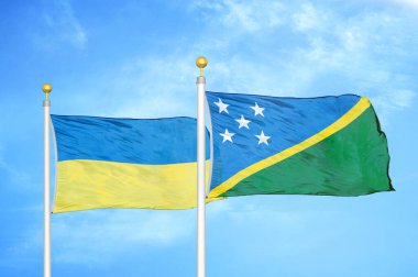 Ukrayna ve Solomon Adaları bayrak direkleri ve mavi bulutlu arka planda iki bayrak