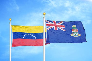 Venezuela ve Cayman Adaları bayrak direkleri ve mavi bulutlu arka planda iki bayrak
