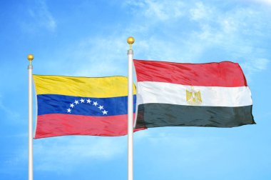 Venezuela ve Mısır bayrak direkleri ve mavi bulutlu arka planda iki bayrak