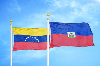 Venezuela ve Haiti bayrak direkleri ve mavi bulutlu arka planda iki bayrak
