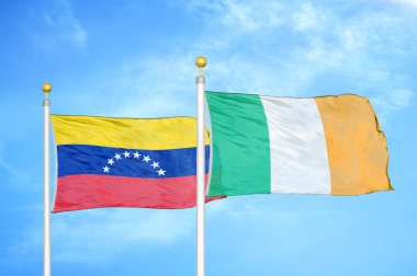 Venezuela ve İrlanda bayrak direkleri ve mavi bulutlu arka planda iki bayrak