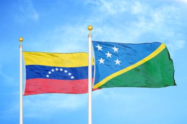 Venezuela ve Solomon Adaları bayrak direkleri ve mavi bulutlu arka planda iki bayrak