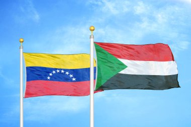 Venezuela ve Sudan bayrak direkleri ve mavi bulutlu arka planda iki bayrak
