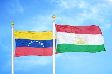 Venezuela ve Tacikistan bayrak direkleri ve mavi bulutlu arka planda iki bayrak