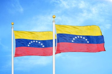 Venezuela bayrak direğinde iki bayrak ve mavi bulutlu arka plan