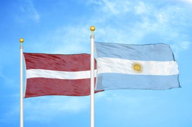 Letonya ve Arjantin bayrak direkleri üzerinde iki bayrak ve mavi bulutlu arka plan