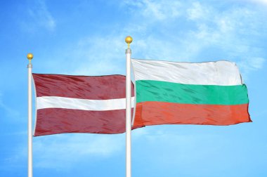 Letonya ve Bulgaristan bayrak direkleri ve mavi bulutlu arka planda iki bayrak