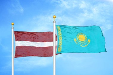 Letonya ve Kazakistan bayrak direkleri ve mavi bulutlu arka planda iki bayrak