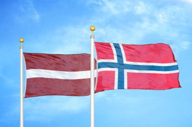 Letonya ve Norveç bayrak direkleri ve mavi bulutlu arka planda iki bayrak