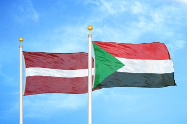 Letonya ve Sudan bayrak direkleri ve mavi bulutlu arka planda iki bayrak