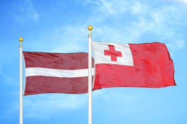 Letonya ve Tonga bayrak direkleri ve mavi bulutlu arka planda iki bayrak