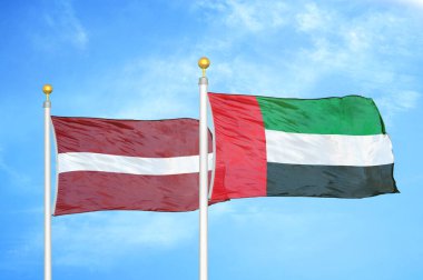 Letonya ve Birleşik Arap Emirlikleri bayrak direkleri ve mavi bulutlu arka planda iki bayrak