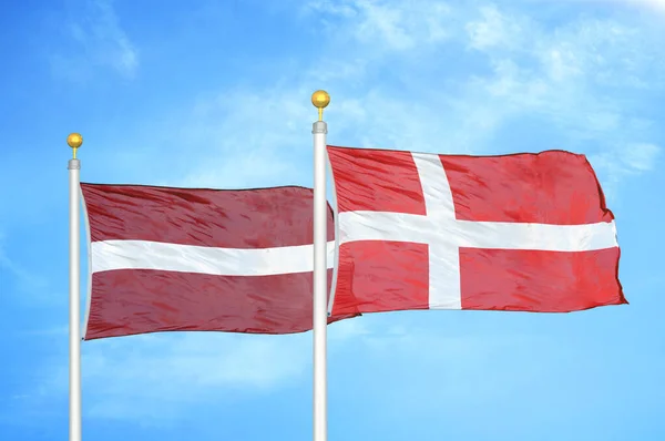 Letonya Danimarka Bayrak Direkleri Mavi Bulutlu Arka Planda Iki Bayrak — Stok fotoğraf