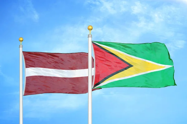 Letonya Guyana Bayrak Direkleri Mavi Bulutlu Arka Planda Iki Bayrak — Stok fotoğraf