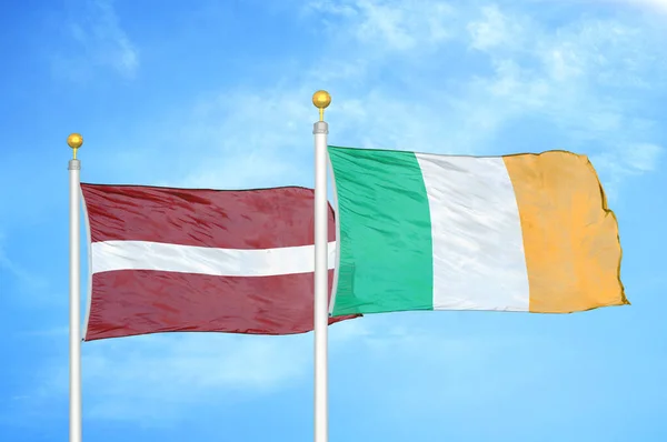 Łotwa Irlandia Dwie Flagi Maszcie Flagowym Niebieskie Zachmurzone Tło Nieba — Zdjęcie stockowe