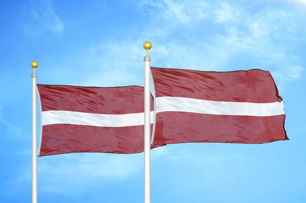 Latvia Latvia Two Flags Flagpoles Blue Cloudy Sky Background — Stock Photo, Image