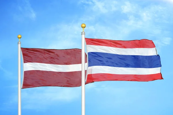 Łotwa Tajlandia Dwie Flagi Maszcie Flagowym Niebieskie Zachmurzone Tło Nieba — Zdjęcie stockowe