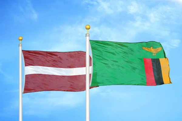 Łotwa Zambia Dwie Flagi Maszcie Flagowym Niebieskie Zachmurzone Tło Nieba — Zdjęcie stockowe