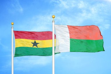 Gana ve Madagaskar bayrak direkleri ve mavi bulutlu arka planda iki bayrak