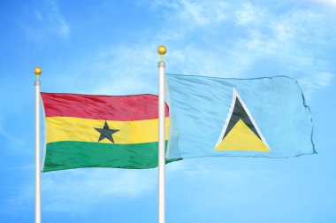 Gana ve Saint Lucia bayrak direkleri ve mavi bulutlu arka planda iki bayrak