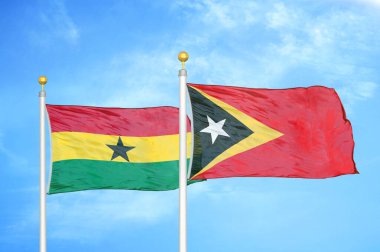 Gana ve Timor-Leste Doğu Timor bayrak direkleri üzerinde iki bayrak ve mavi bulutlu arka plan
