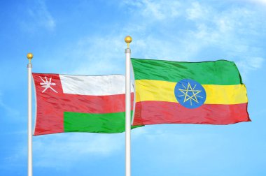 Umman ve Etiyopya bayrak direğinde iki bayrak ve mavi bulutlu arka plan