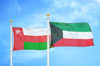 Umman ve Kuveyt bayrak direğinde iki bayrak ve mavi bulutlu arka plan