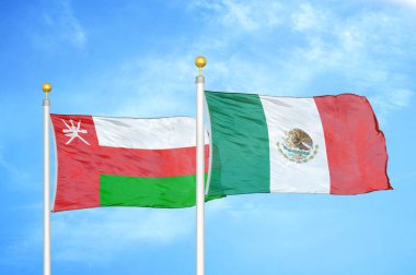 Umman ve Meksika bayrak direğinde iki bayrak ve mavi bulutlu arka plan