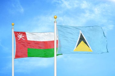 Umman ve Aziz Lucia bayrak direğinde iki bayrak ve mavi bulutlu bir arka plan.