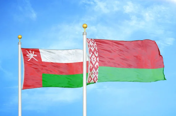 Oman Biélorussie Deux Drapeaux Sur Les Mâts Bleu Ciel Nuageux — Photo