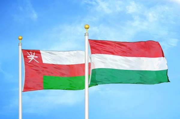 Oman Hungary Two Flags Flagpoles Blue Cloudy Sky Background — Stock Photo, Image