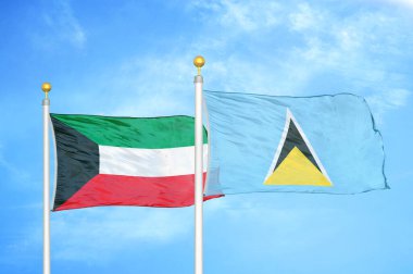 Kuveyt ve Saint Lucia bayrak direkleri ve mavi bulutlu arka planda iki bayrak