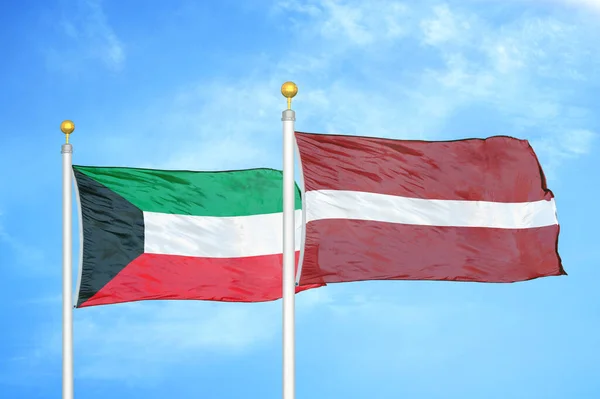 クウェートとラトビアの旗竿と青空の背景に2つの旗 — ストック写真
