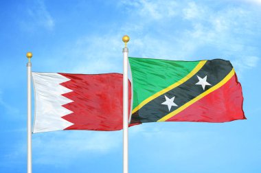 Bahreyn ve Saint Kitts ve Nevis bayrak direğinde iki bayrak ve mavi bulutlu arka plan