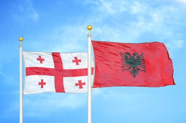 Gürcistan ve Arnavutluk bayrak direkleri ve mavi bulutlu arka planda iki bayrak