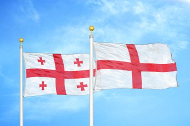 Gürcistan ve İngiltere bayrak direkleri ve mavi bulutlu arka planda iki bayrak