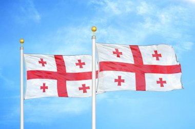 Gürcistan bayrak direkleri ve mavi bulutlu arka planda iki bayrak