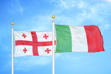 Gürcistan ve İtalya bayrak direkleri ve mavi bulutlu arka planda iki bayrak