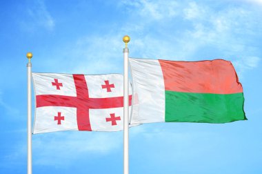 Gürcistan ve Madagaskar bayrak direkleri ve mavi bulutlu arka planda iki bayrak