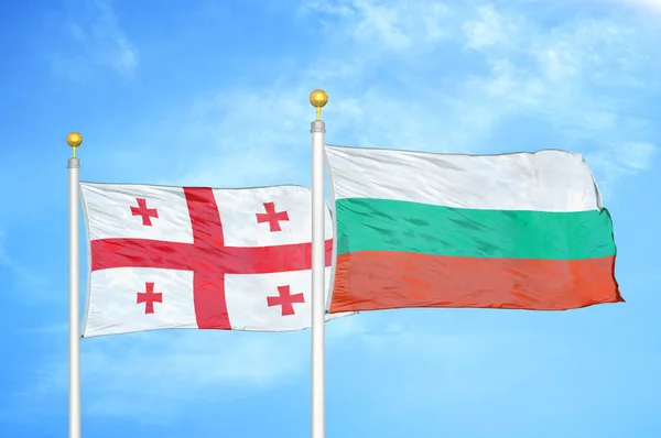 Georgië Bulgarije Twee Vlaggen Vlaggenmasten Blauwe Bewolkte Hemelachtergrond — Stockfoto