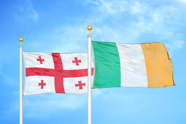 Géorgie Irlande Deux Drapeaux Sur Les Mâts Bleu Ciel Nuageux — Photo