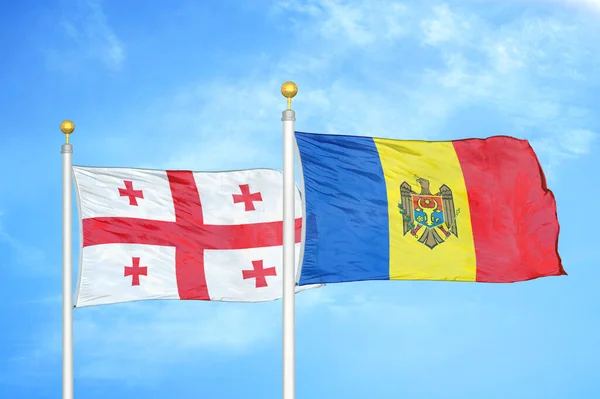 Georgië Moldavië Twee Vlaggen Vlaggenmasten Blauwe Bewolkte Hemelachtergrond — Stockfoto