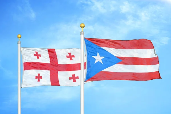 Gruzie Portoriko Dvě Vlajky Vlajkových Stožárech Modrá Oblačná Obloha Pozadí — Stock fotografie