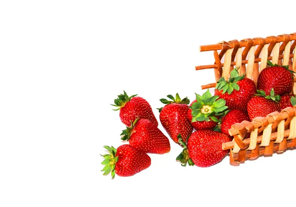 Bir sepet beyaz zemin üzerine saçılan Olgun kırmızı çilek