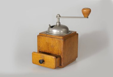 Stüdyoda beyaz bir arka planda izole edilmiş eski bir el yapımı kahve değirmeni.